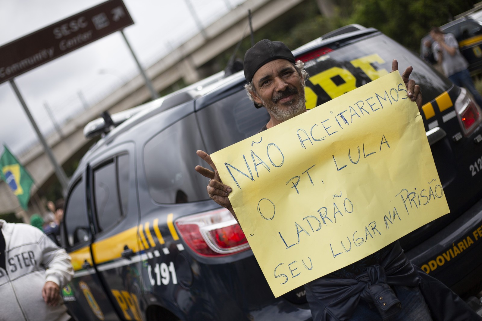 Antidemocrático. Manifestante exibe cartaz contra o resultado das urnas ao lado de viatura da Polícia Rodoviária Federal, na Rodovia Helio Smidt (SP-019) — Foto: Maria Isabel Oiveira/Agência O Globo