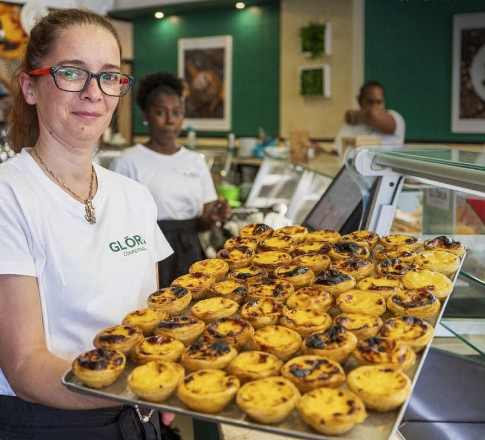 Funcionária da Confeitaria Glória, em Amadora, mostra a fornada dos pastéis de nata, apontados como os melhores da Grande Lisboa — Foto: Reprodução / Instagram / Confeitaria Glória