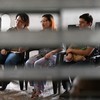 Fiorella Turchkeim (2ª esq.) e Andrea Ordoñez (2ª dir.) dão as mãos durante um culto em uma organização de inspiração anglicana, um dos poucos espaços abertos a devotos LGBTQIAP+ em San Salvador - MARVIN RECINOS / AFP