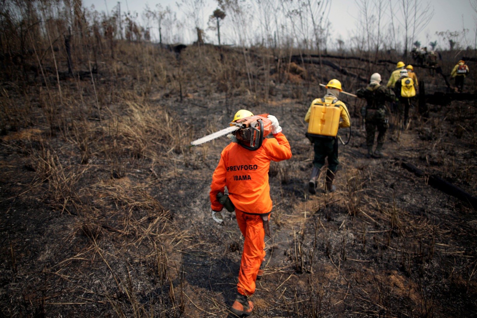 Membros da brigada de incêndio e soldados do Exército do Instituto Brasileiro do Meio Ambiente e dos Recursos Naturais Renováveis (Ibama) tentam controlar pontos quentes em uma área da selva amazônica perto de Apuí, no AmazonasREUTERS