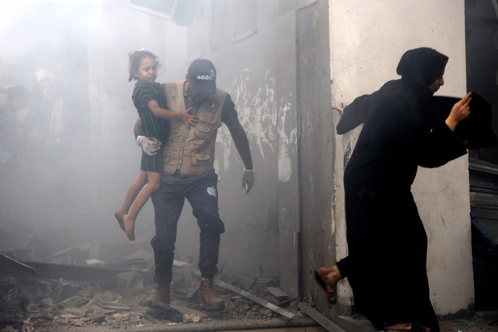 Família palestina foge nos escombros durante represália de Israel — Foto: Eyad Al-Baba/AFP