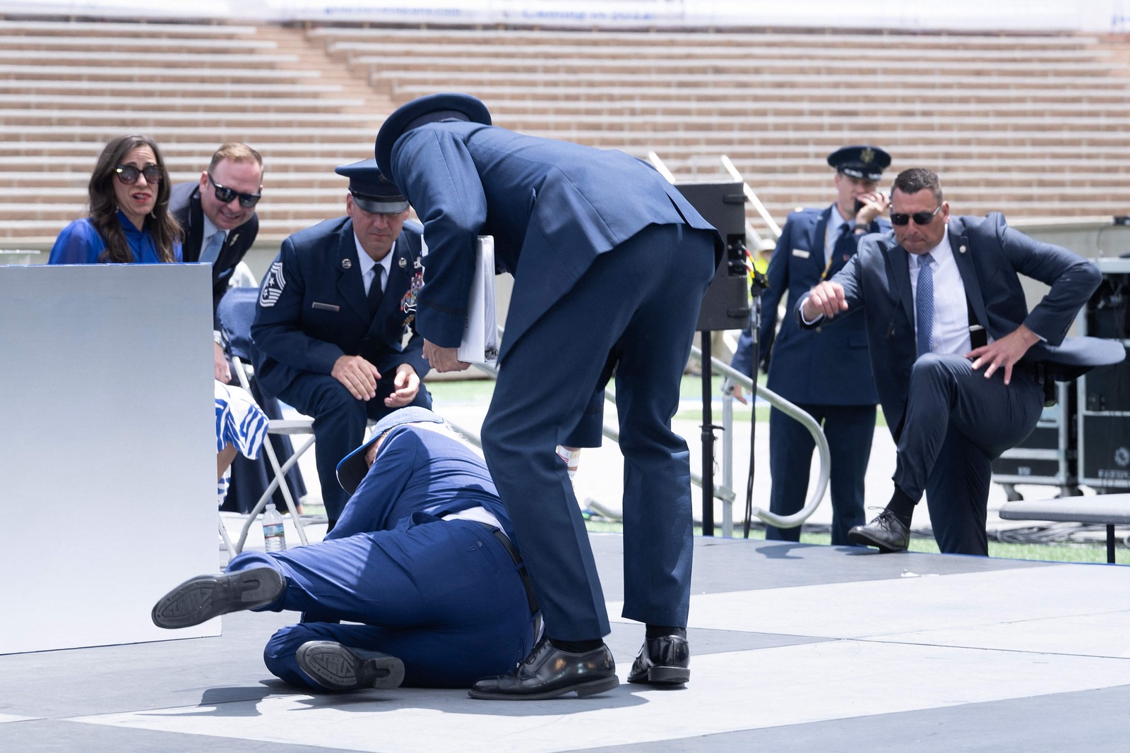 O político estava em um palco montado para o evento e se desequilibrou logo após cumprimentar um militar — Foto: Brendan Smialowski / AFP