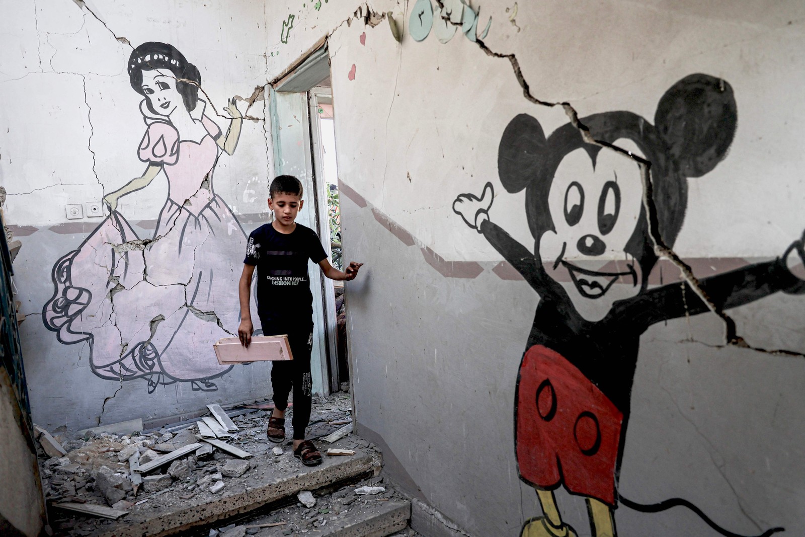 Criança anda pelo interior de um prédio destruído na Faixa de Gaza, após um ataque aéreo feito por Israel — Foto: Said Khatib/AFP