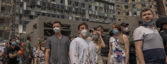 Equipe médica (C) é vista em meio aos escombros do prédio destruído do Hospital Infantil Okhmatdyt, o maior da Ucrânia, após um ataque com mísseis russos em Kiev — Foto: Roman Pilipey/AFP