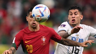 O zagueiro português João Cancelo e o zagueiro uruguaio Mathias Olivera brigam pela bola  — Foto: Kirill KUDRYAVTSEV / AFP