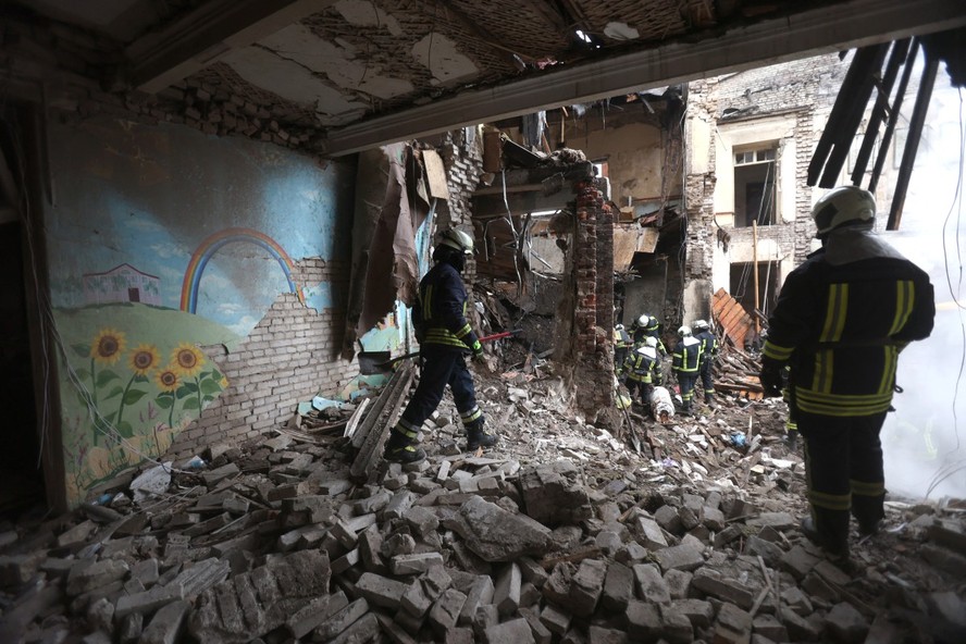 Bombeiros retiram destroços de prédio escolar em Sloviansk, Ucrânia, após bombardeio russo