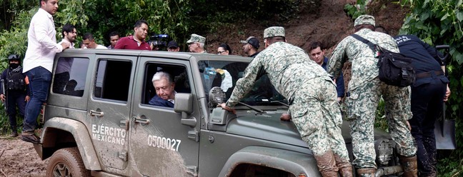 O presidente mexicano, Andrés Manuel López Obrador, olha pela janela enquanto o veículo que o transportava fica preso na lama durante uma visita à comunidade Kilometro 42, perto de Acapulco, estado de Guerrero, México, após a passagem do furacão Otis — Foto: RODRIGO OROPEZA / AFP