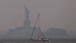 Estátua da Liberdade envolvida por névoa avermelhada, resultado dos incêndios florestais canadenses -  Foto SPENCER PLATT/GETTY IMAGES NORTH AMERICA/Getty Images via AFP