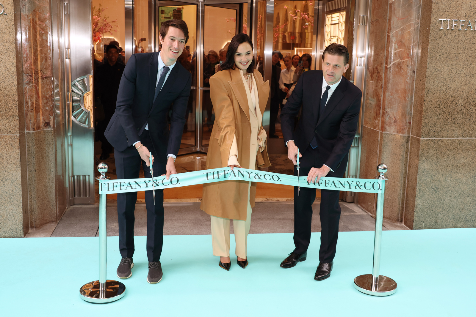 O vice-presidente executivo de produtos e comunicações, Alexandre Arnault, a atriz Gal Gadot e Anthony Ledru, presidente e CEO da Tiffany, cortam a fita reinaugurando a loja icônica da marca em NY — Foto: AFP