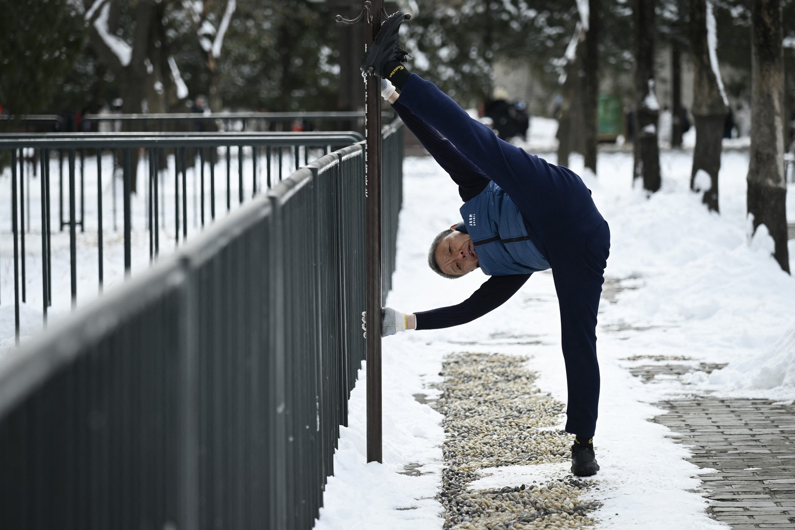 Um homem se exercita em um parque após uma nevasca em Pequim — Foto: WANG ZHAO/AFP