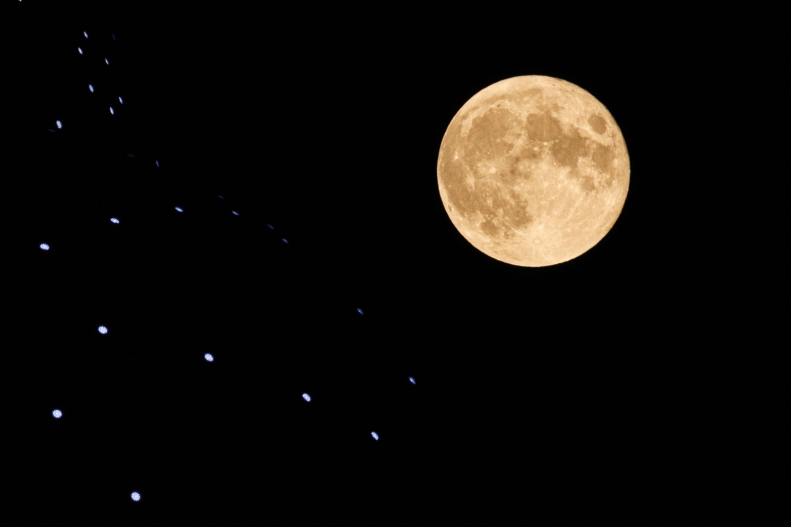 A última superlua do ano, também conhecida como Harvest Moon, é vista surgindo no topo do monumento Atomium em Bruxelas — Foto: Simon Wohlfahrt / AFP