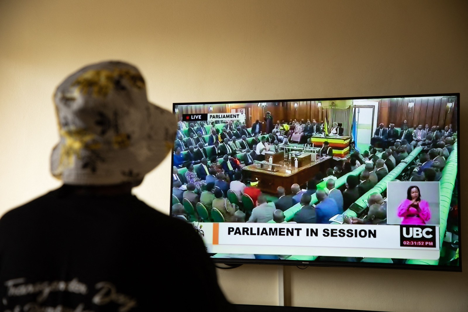 Mulher trans que foi recentemente atacada em Uganda assiste à transmissão da sessão do parlamento que aprovou o projeto de lei anti-LGBTQIA+ em 21 de março de 2023 — Foto: Stuart Tibaweswa / AFP