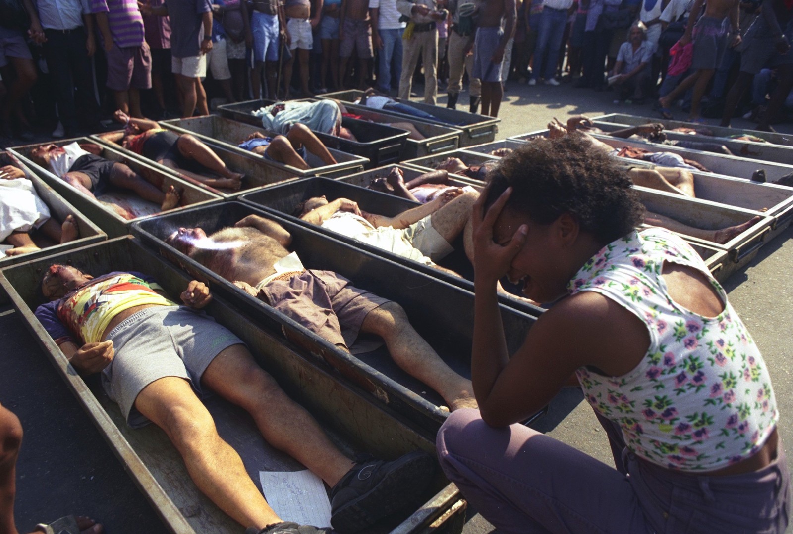 Mulher chora diante dos corpos de moradores de Vigário Geral assassinados por um grupo de extermínio, integrado por PMs, na madrugada de 29 de agosto de 1993. A imagem chocante correu o mundo — Foto: Custodio Coimbra