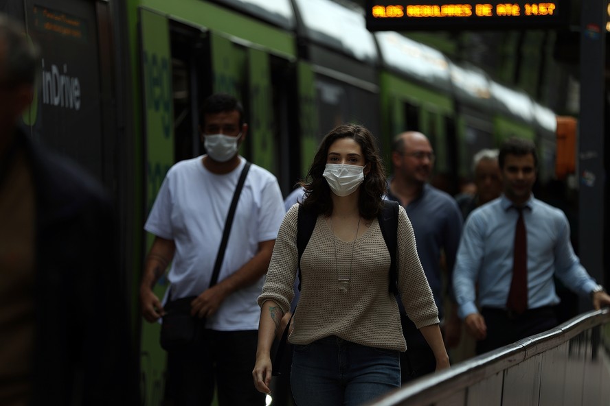 Pessoas de máscaras em transportes públicos