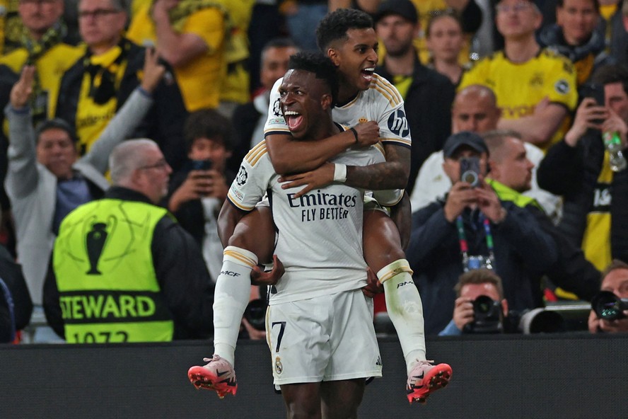Real Madrid's Brazilian forward #07 Vinicius Junior (front) celebrates after scoring his team second goal with Real Madrid's Brazilian forward #11 Rodrygo (rear) during the UEFA Champions League final football match between Borussia Dortmund and Real Madrid, at Wembley stadium, in London, on June 1, 2024. (Photo by Adrian DENNIS / AFP)