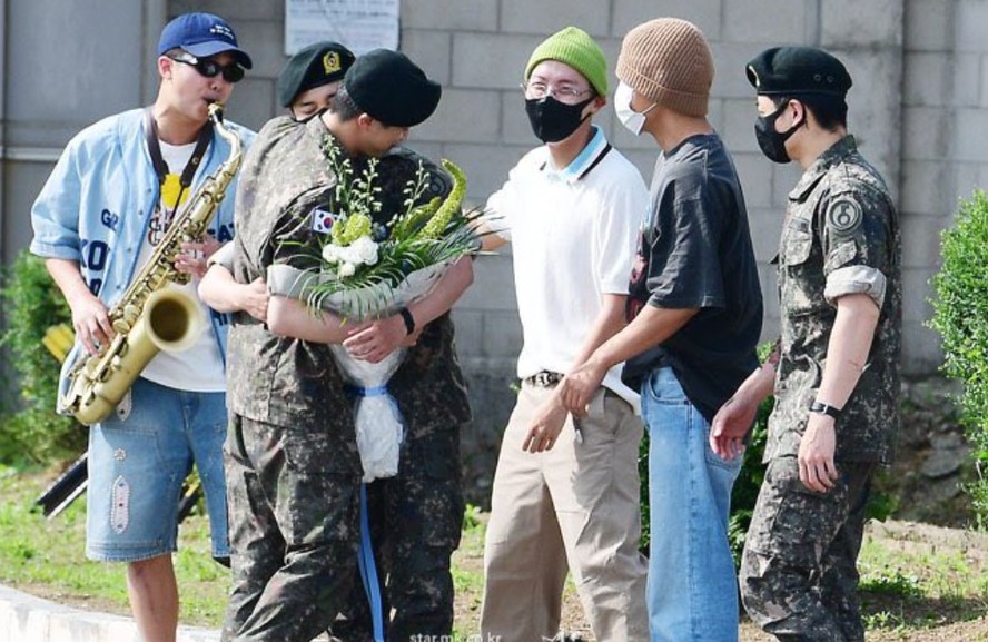 Jin é recebido por seus companheiros do BTS, na saída da base militar