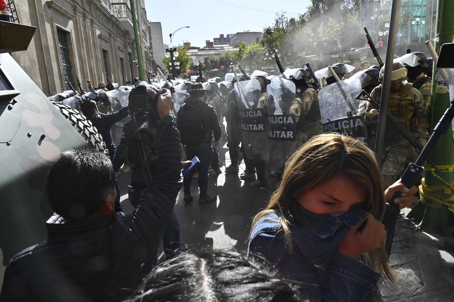 Pessoas se afastam do gás lacrimogêneo disparado por tropas militares em frente ao Palácio Quemado, na Plaza de Armas, em La Paz
