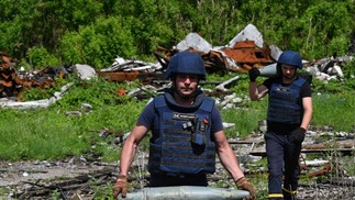 Militares especializados removem explosivos na vila de Yahidne, nos territórios libertados da região de Chernihiv, Ucrânia — Foto: SERGEI SUPINSKY / AFP