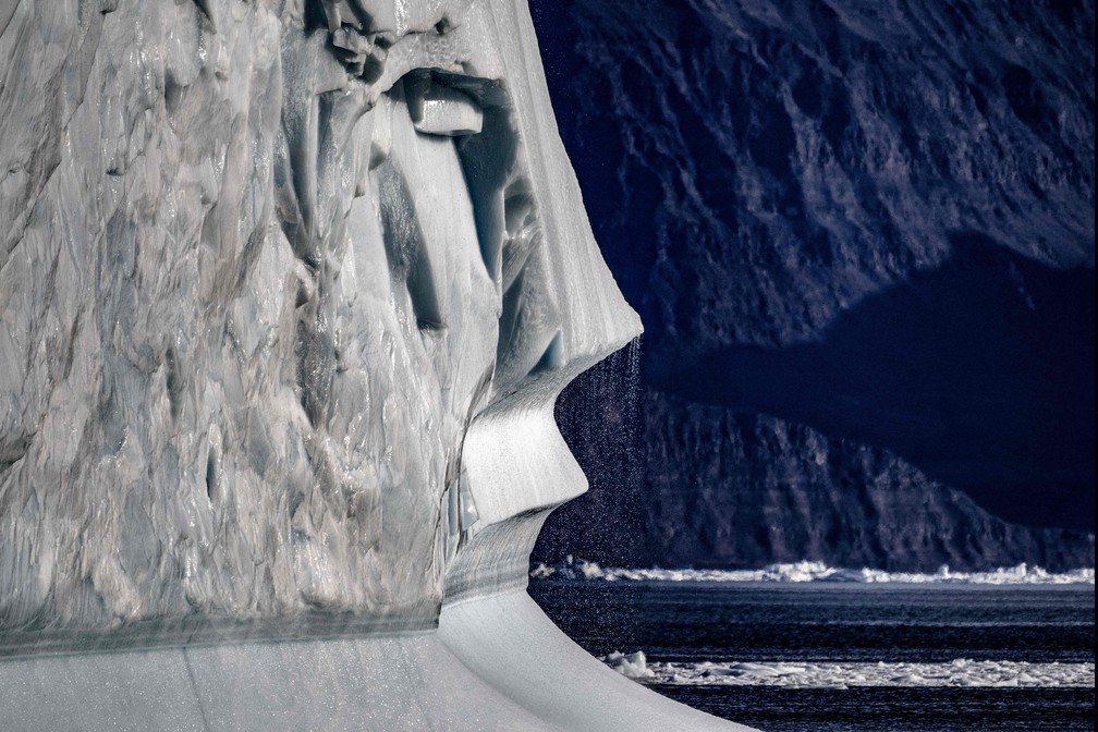 Contraste. Um iceberg em primeiro plano, flutuam ao longo do fiorde Scoresby Sound (segundo plano), no leste da Groenlândia. — Foto: Olivier MORIN/AFP