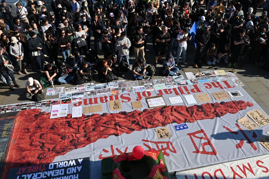 Apoiadores, manifestantes e membros da mídia assistem a uma reconstituição do incidente da Praça da Paz Celestial em Trafalgar Square, em Londres, em 4 de junho de 2023, no 34º aniversário da repressão de 1989 às manifestações pró-democracia em Pequim