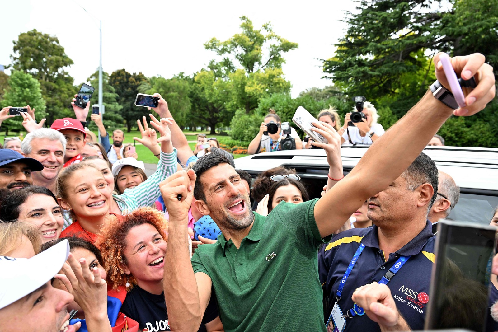 Tenista sérvio Novak Djokovic tira selfies com seus torcedores em Melbourne, depois de vencer o aberto da Austrália — Foto: SAEED KHAN/AFP