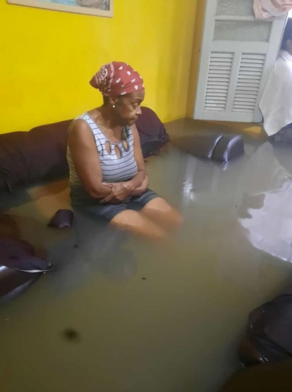 A aposentada Norma de Morais, de 70 anos, teve a casa inundada pela chuva, no Jardim América, Zona Norte do Rio — Foto: Reprodução