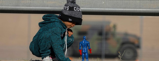 Criança venezuelana brinca com boneco do Capitão América, em Rio Grande em Ciudad Juarez, na fronteira do México com os EUA — Foto: HERIKA MARTINEZ/AFP