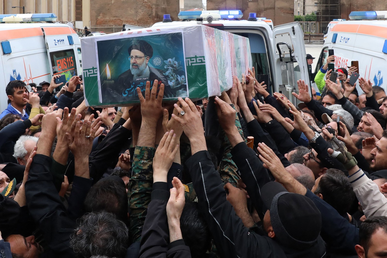 Esta foto fornecida pelo gabinete do presidente iraniano mostra pessoas em luto reunidas em torno do caixão durante um cortejo fúnebre em Tabriz, capital da província do Azerbaijão Oriental do Irã, em 21 de maio de 2024, pelo falecido presidente Ebrahim Rais — Foto: Presidência Iraniana / AFP