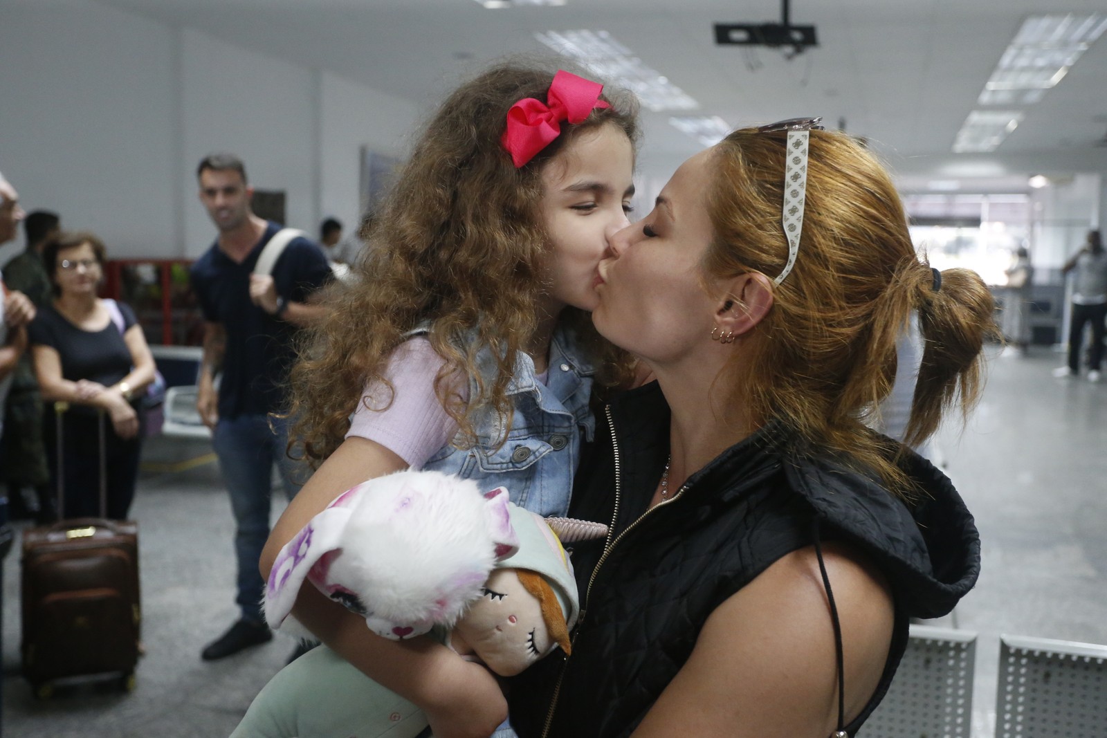 Mãe e filha no aeroporto Galeão após repatriação feita pela Força Aérea Brasileira (FAB) — Foto: Fabiano Rocha/Agência O Globo