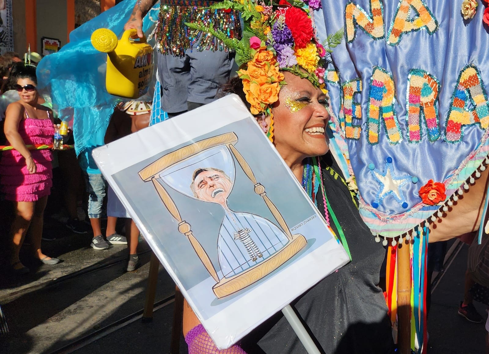 Foliões desfilam no Céu na Terra com placa que tinha uma caricatura de Bolsonaro dentro de uma ampulheta — Custódio Coimbra/Agência O Globo 