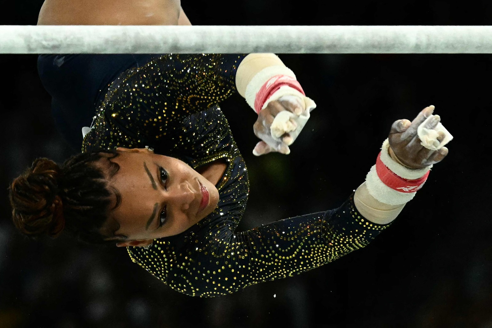 A brasileira Lorrane Oliveira compete na prova de barras assimétricas na final por equipes femininas de ginástica artística — Foto: Loic VENANCE / AFP