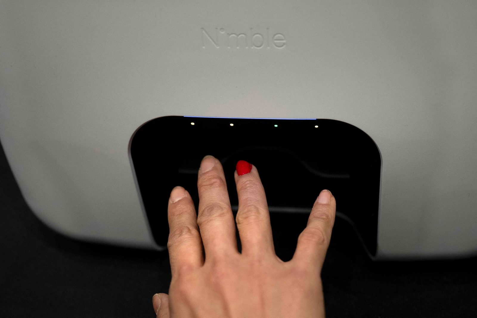Visitante testa dispositivo Nimble, da Nimble Beauty, para pintar a unha — Foto: Brendan Smialowski / AFP