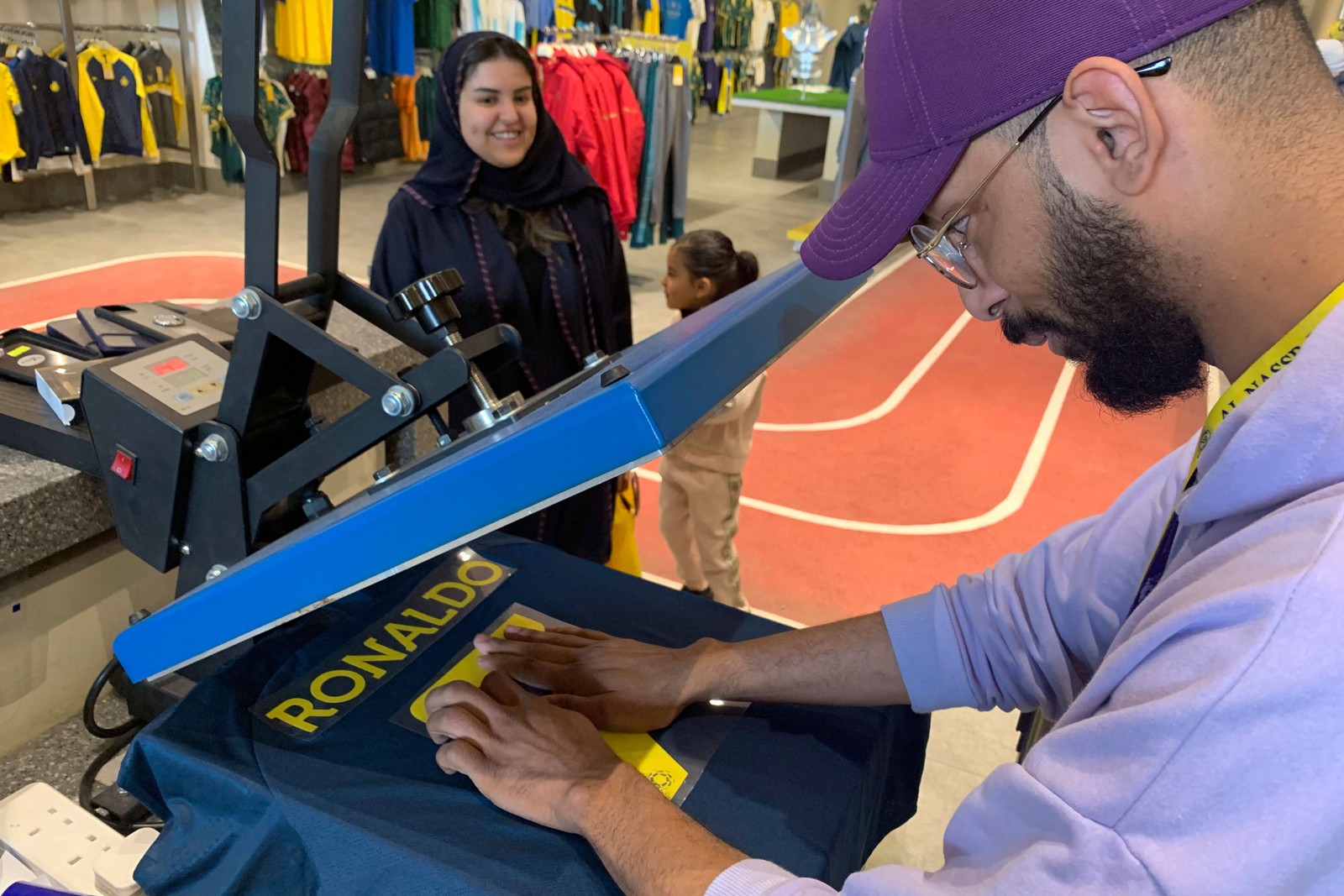 Funcionários tiveram muito trabalho para estampar o número e o nome do jogador em diversas camisas — Foto: Fayez Nureldine / AFP