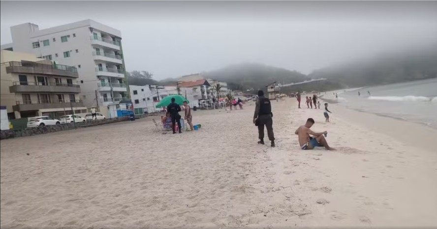 Agentes percorrem a praia em Arraial do Cabo informado que o acesso à área está permitido apenas a moradores