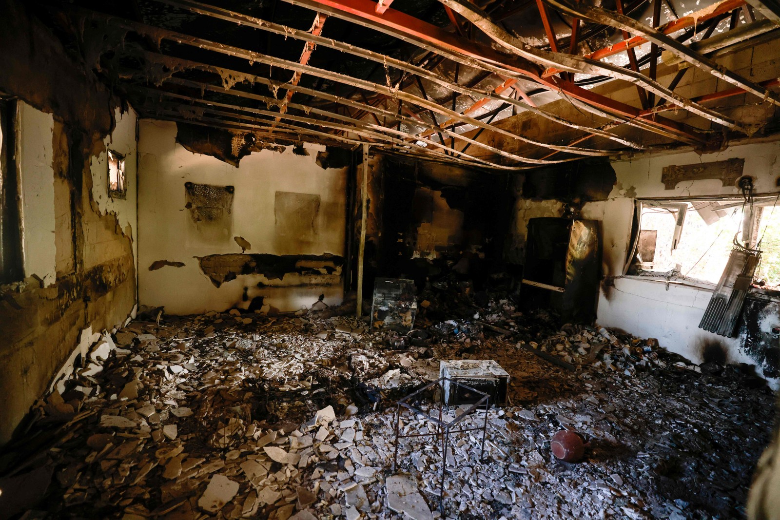 Interior de um edifício destruido no kibutz Nir Oz, ao longo da fronteira com a Faixa de Gaza, após o ataque de 7 de outubro por militantes do Hamas. — Foto: Menahem KAHANA / AFP