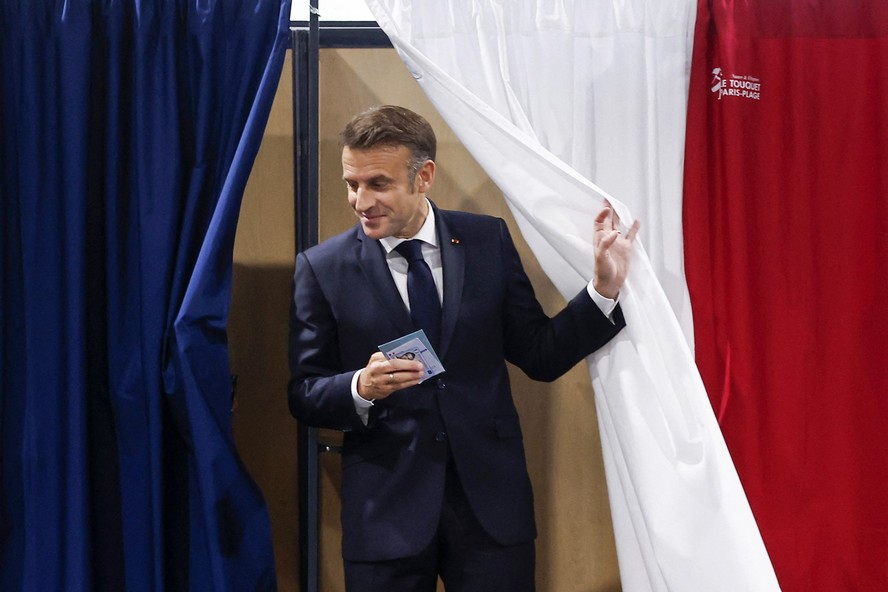 O presidente da França, Emmanuel Macron, sai de uma cabine de votação ara votar no segundo turno das eleições em uma seção eleitoral em Le Touquet, norte da França, em 7 de julho de 2024