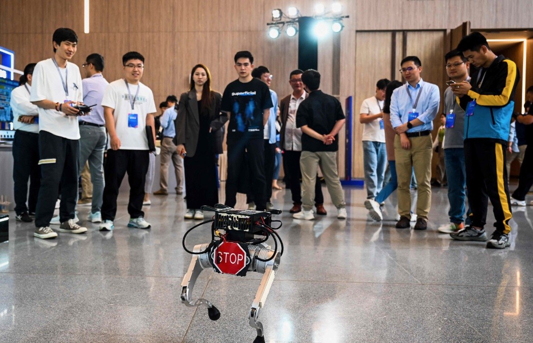 Visitantes observam um dos protótipos de robô na conferência realizada em Xangai — Foto: AFP