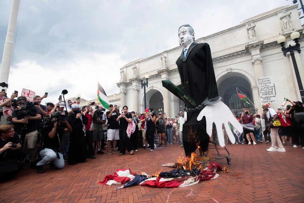 Manifestantes pró-Palestina queimam bandeira dos EUA e boneco representando o premier israelense, Benjamin Netanyahu, em protesto em Washington — Foto: Matthew Hatcher / AFP