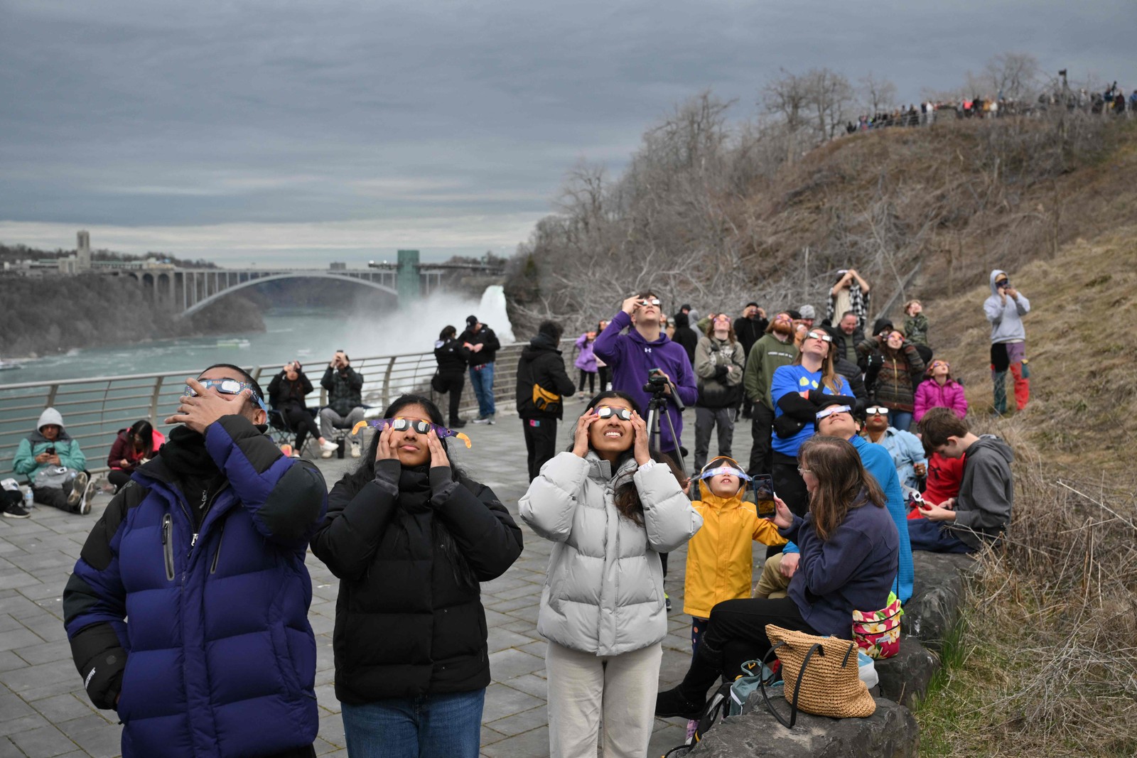 Pessoas olham para o sol durante eclipse solar total no Niagara Falls State Park, em Nova York. — Foto: ANGELA WEISS / AFP