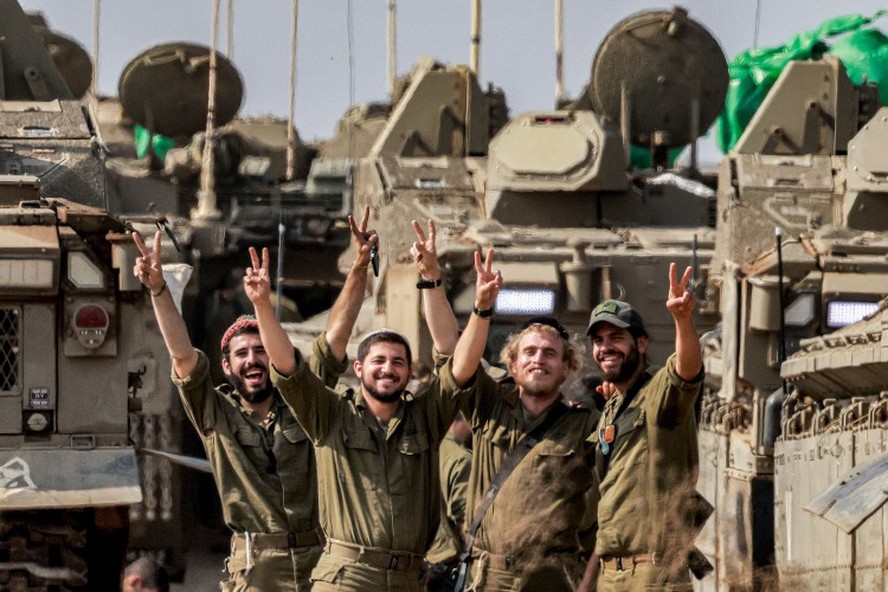 Soldados do exército israelense posam perto de um veículo blindado perto da fronteira com Gaza, no sul de Israel