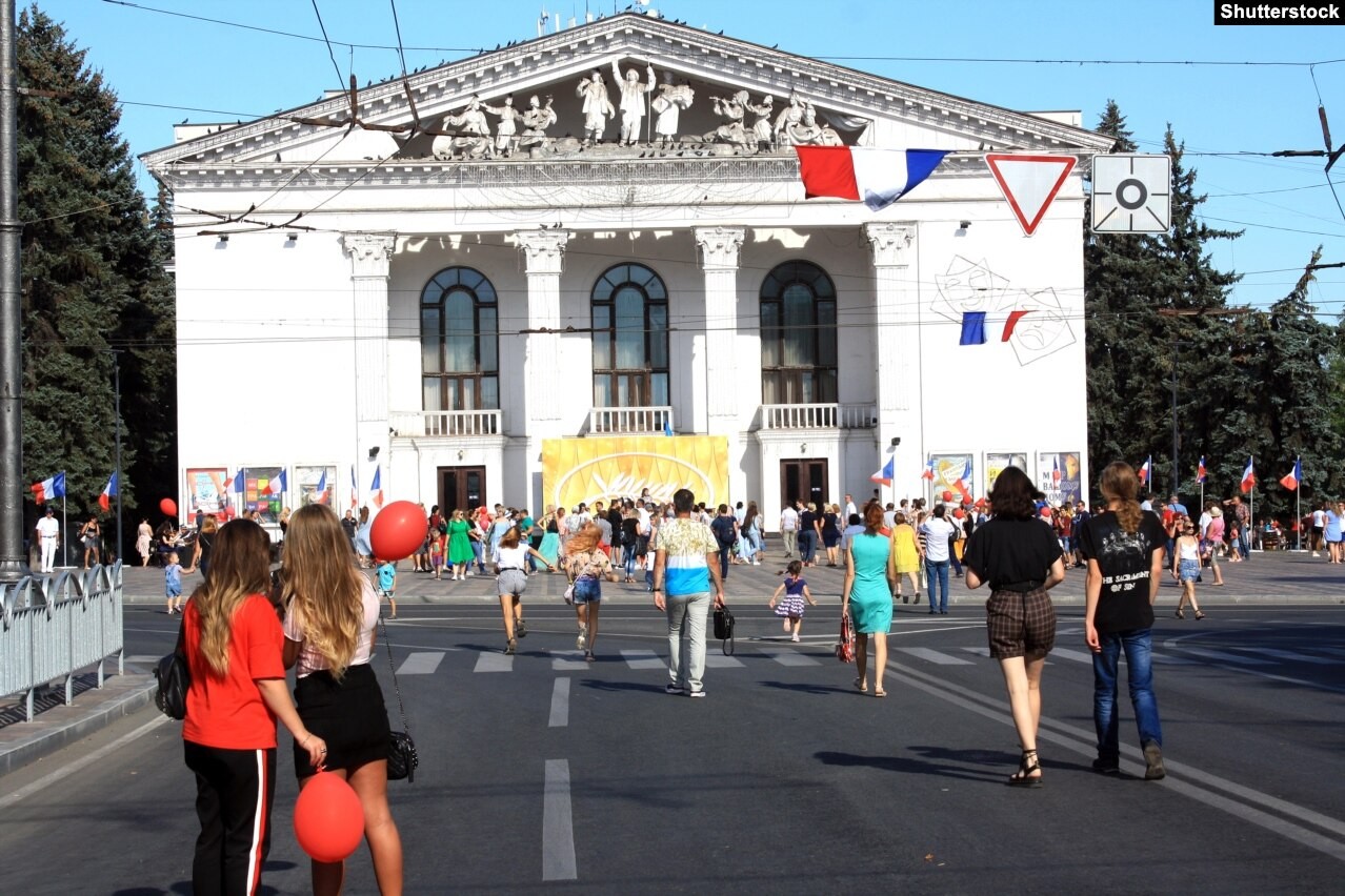 Moradores de Mariupol caminham em frente ao Teatro Regional de Drama de Donetsk, durante festival francês, em 2019 — Foto: Shutterstock