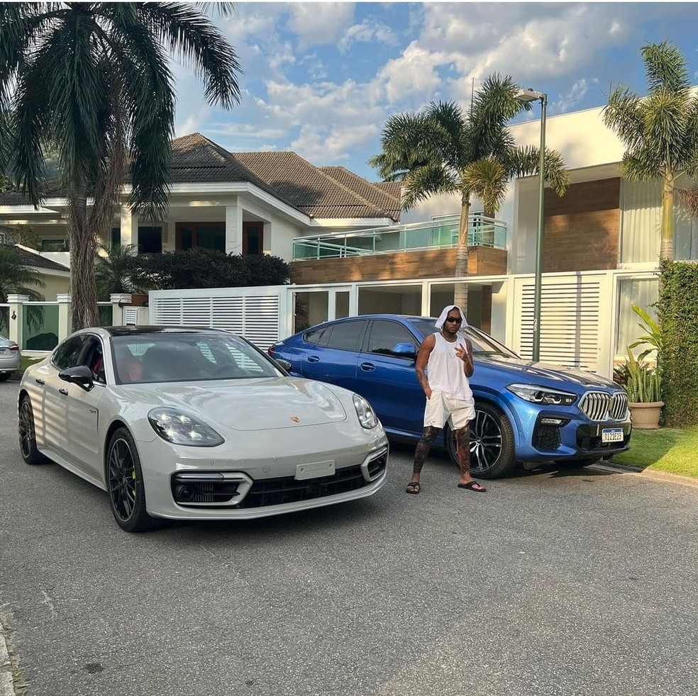 Orochi entre os seus dois carros avaliados em mais de dois milhões de reais — Foto: Reprodução / Instagram