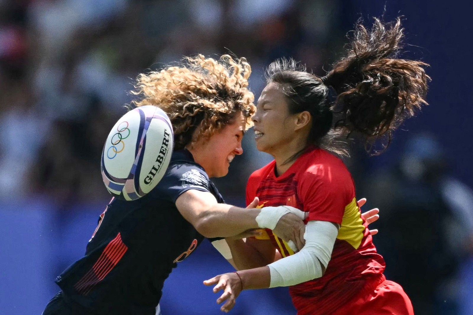 A britânica Ellie Kildunne (E) e a chinesa Liu Xiaoqian (D) durante a partida de rúgbi de sete — Foto: Carl de Souza / AFP