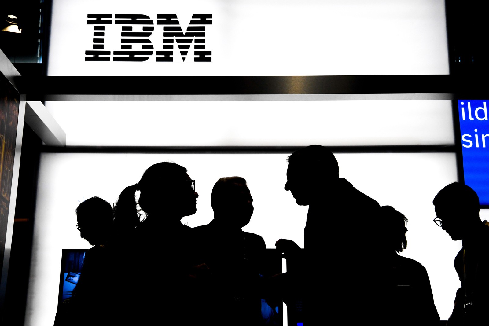 Pessoas conversam em frente a um estande da IBM: empresa está no mercado desde muito antes de a informática revolucionar o mundo