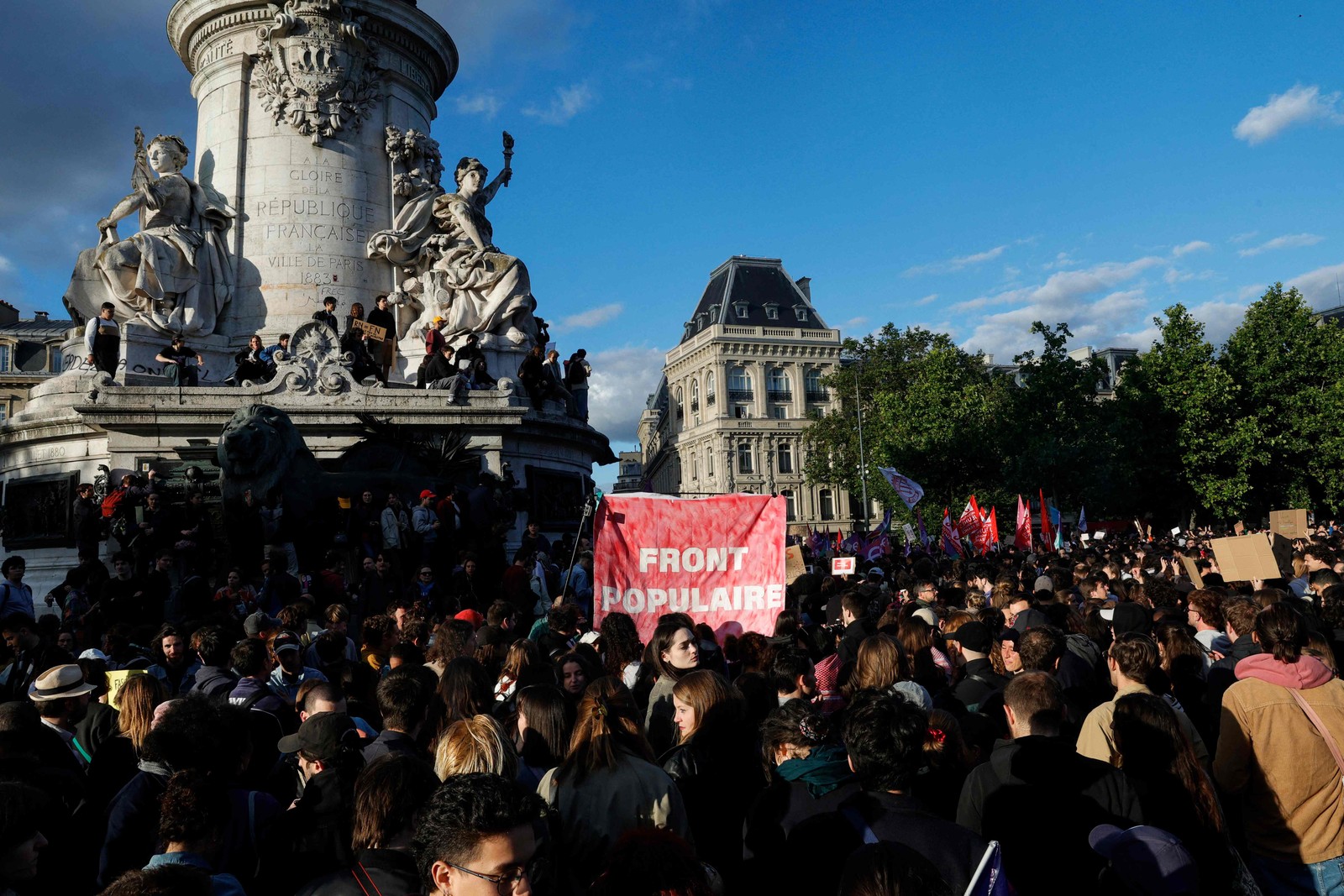 Manifestantes seguram um cartaz onde se lê "Frente Popular" enquanto se reúnem na Place de la Republique para manifestar-se contra a vitória do partido francês de extrema-direita Rassemblement National (RN) nas eleições europeias, assumindo uma posição de força nas eleições legislativas antecipadas chamadas pelo presidente francês após os resultados das eleições, em Paris, em 10 de junho de 2024. — Foto: VAN DER HASSELT / AFP