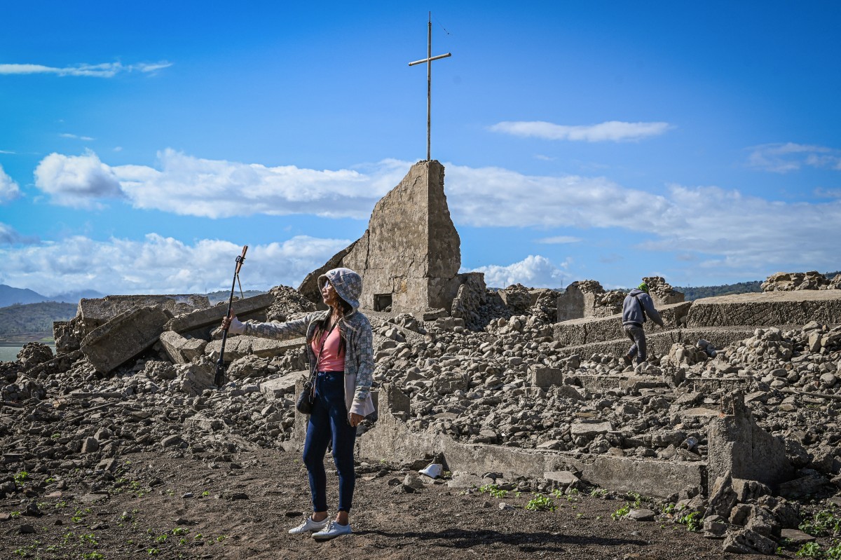 Vestígios da cidade centenária de Pantabangan ressurgiram no norte das Filipinas após o nível da água da barragem baixar em meio a uma seca que assola muitas partes do país — Foto: JAM STA ROSA / AFP