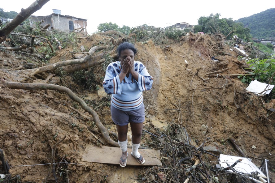 Moradora procura filhos soterrados após deslizamento de terra em Petrópolis, na região serrana do Rio