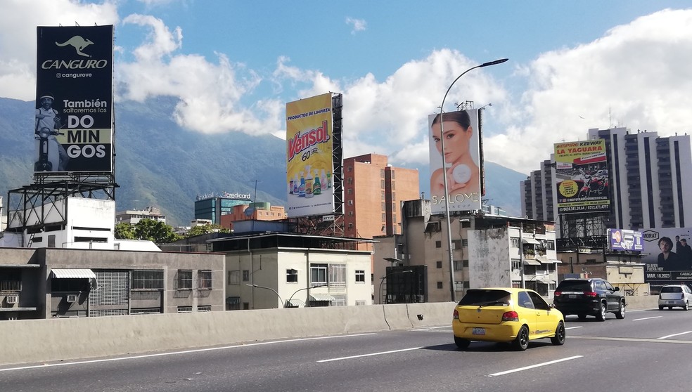 Outdoors de produtos e shows voltaram a povoar a Autopista Francisco Fajardo, rebatizada de Grande Cacique Guaycaipuro, que cruza Caracas — Foto: O Globo