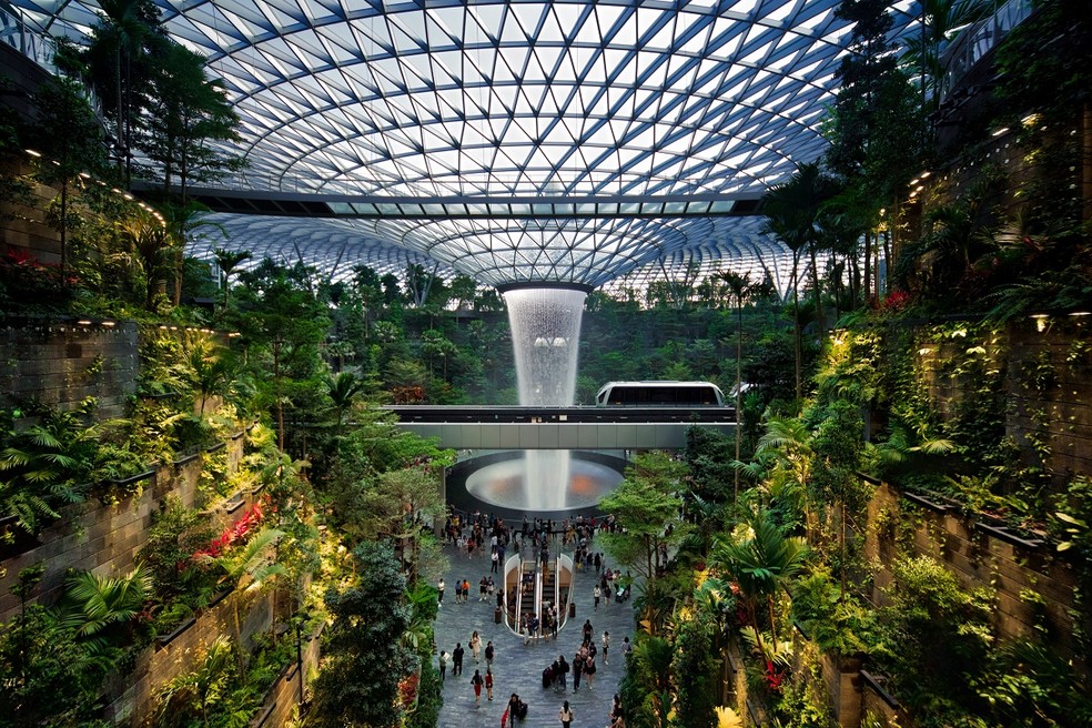 A Rain Vortex, a cachoeira interna cercada por uma mini floresta tropical, marca registrada do Aeroporto Changi, em Cingapura, eleito o melhor do mundo — Foto: Reprodução / Wikimedia Commons