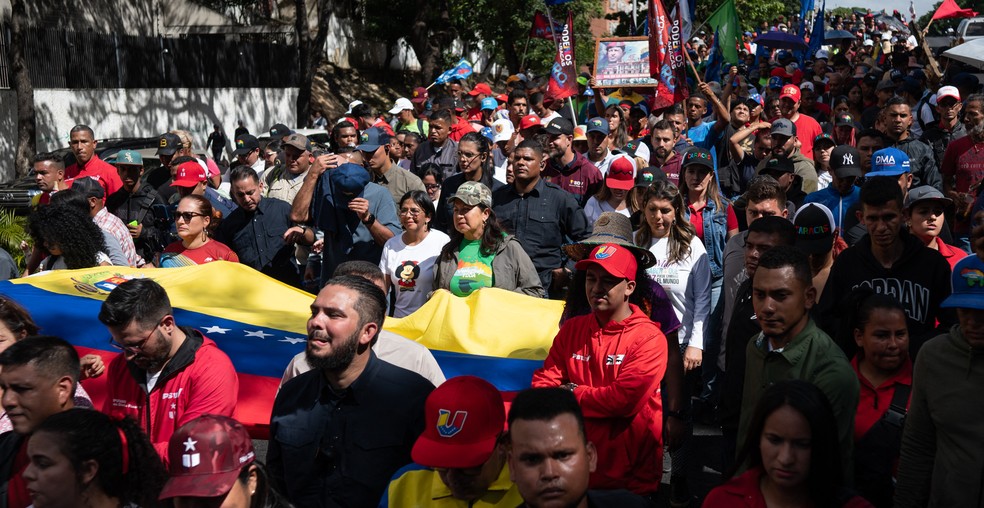 A vice-presidente da Venezuela, Delcy Rodriguez, segura uma bandeira venezuelana durante uma marcha em apoio ao presidente Nicolás Maduro — Foto: Gabriela Oraa/AFP